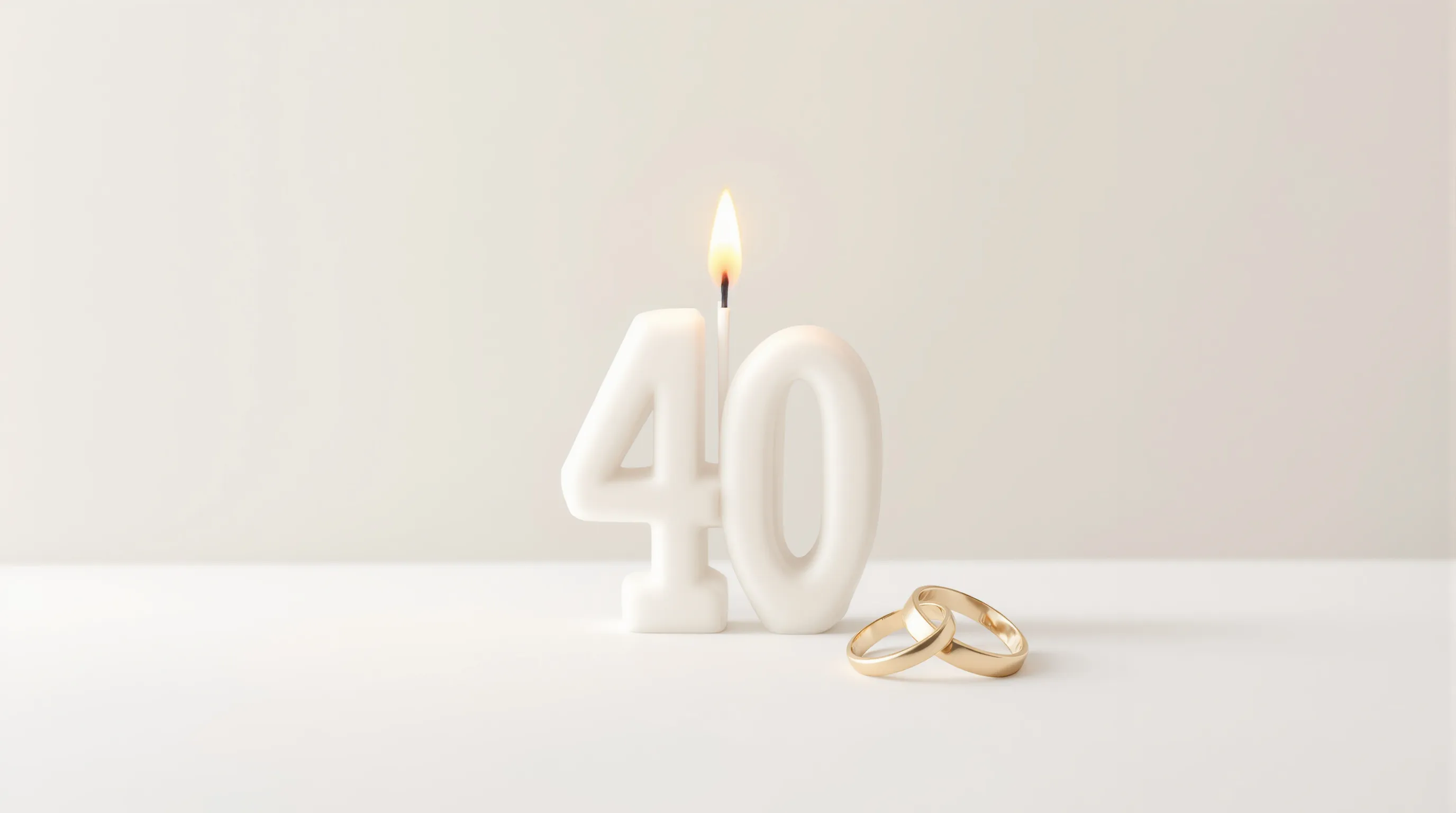 Minimalist number 40 candle with wedding rings on clean background.