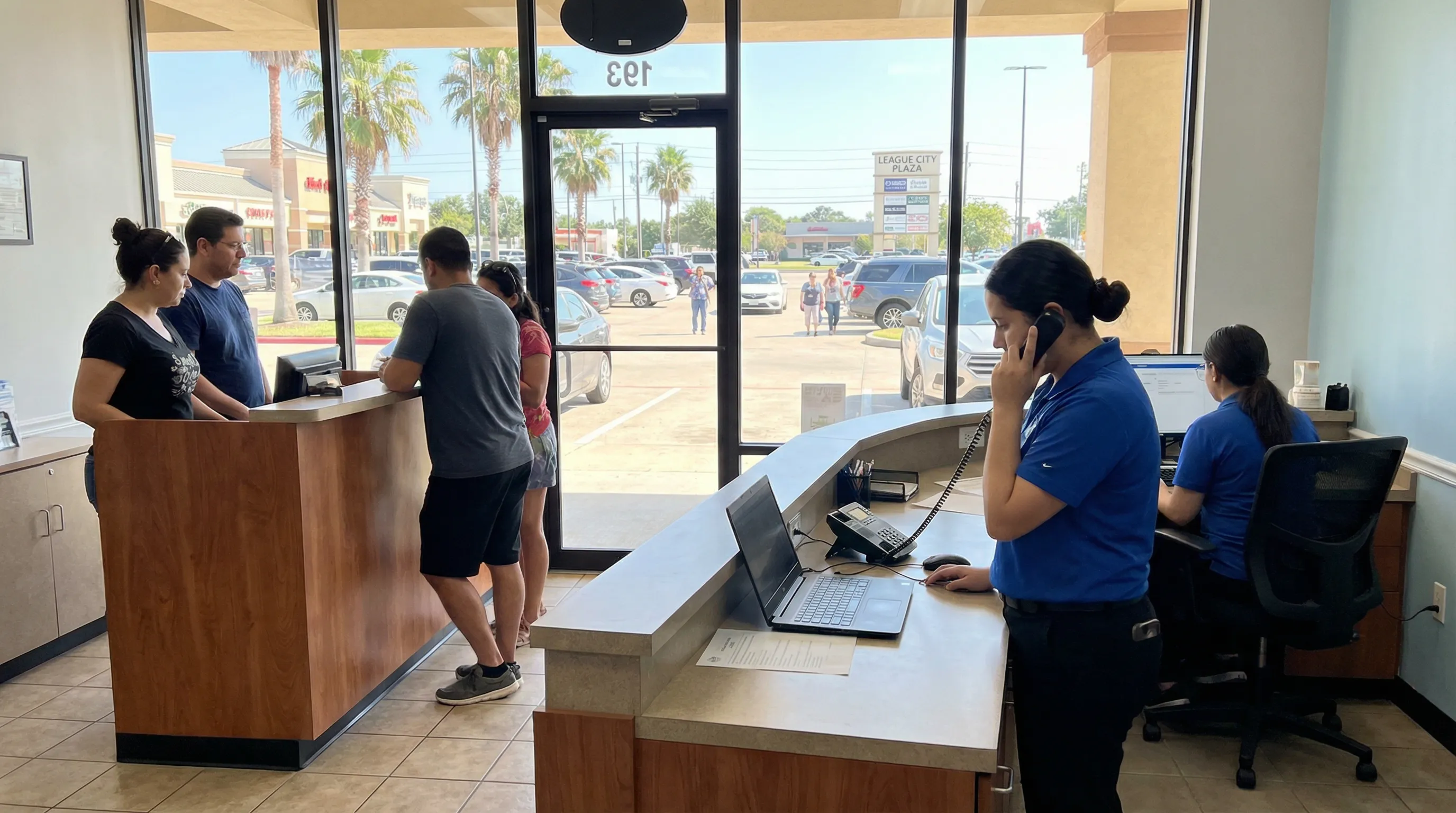 Staff in a League City storefront manage phone calls and online inquiries while customers arrive at the front counter.