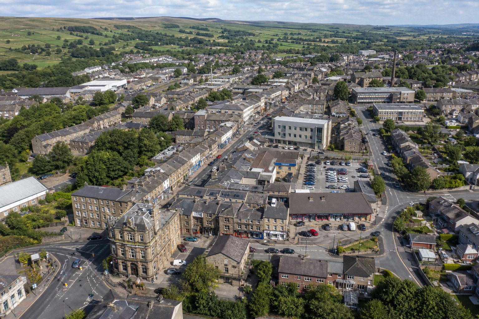 Commercial Mortgages In Haslingden 15 Aerial view of a mixed-use commercial area in a Lancashire town with hills in the distance.